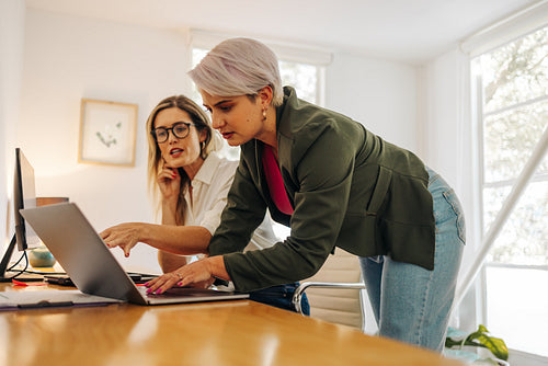 Two young businesswomen working together in a creative office