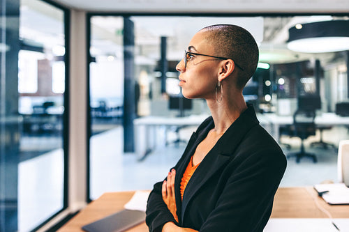 Creative female entrepreneur standing with her arms crossed in an office