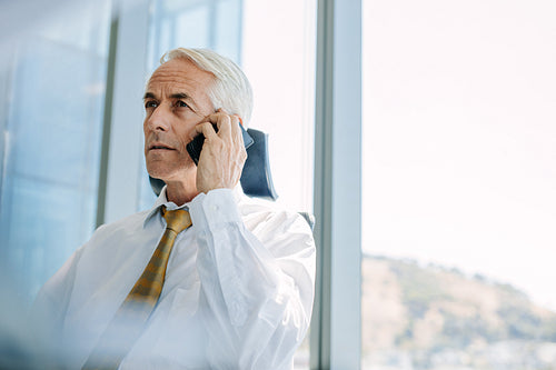 Senior manager using cell phone in office