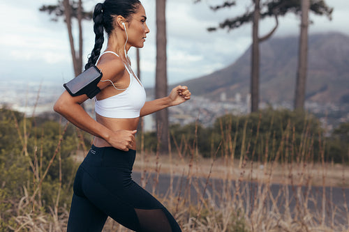 Woman athlete running on country road
