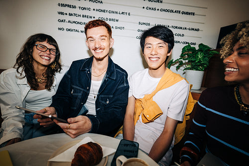Young business friends laughing together in a cafe