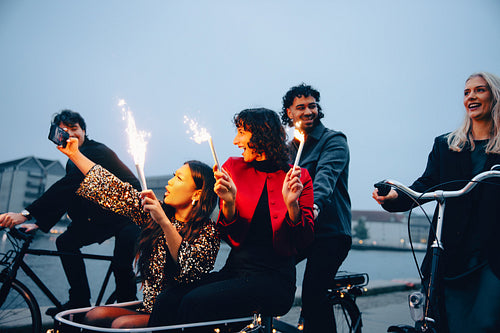Group of friends celebrating with sparklers during an evening bike ride