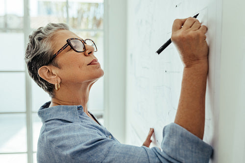 Female architect sketching solutions for her design project in an office