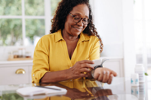 Managing hypertension: Mature woman measuring her blood pressure with a medical device