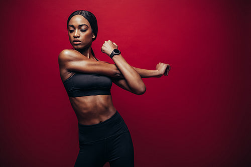 Fit african woman doing stretching exercise