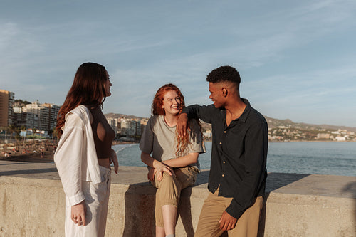 Three happy friends enjoying a sunny day next to the sea