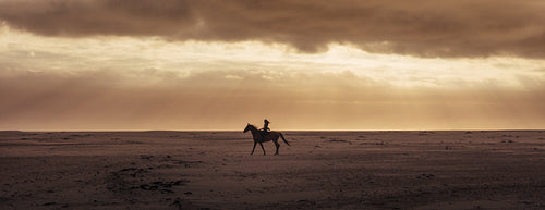 Silhouette of a woman riding horse