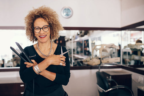 Female hairdresser at the salon holding hairdressing tools