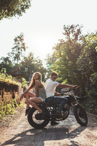 Couple hanging out with motorcycle on village road