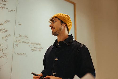 Man presents project ideas at an office whiteboard