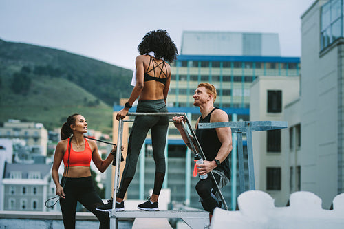 Fitness colleagues standing on rooftop and talking