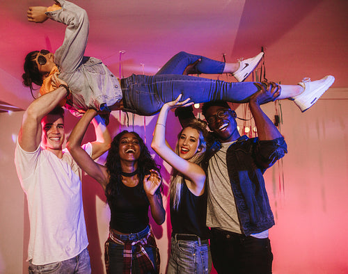 Group of friends carrying their friend at a house party 