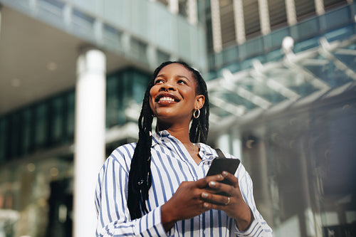 Thoughtful young businesswoman using a smartphone during her morning commute