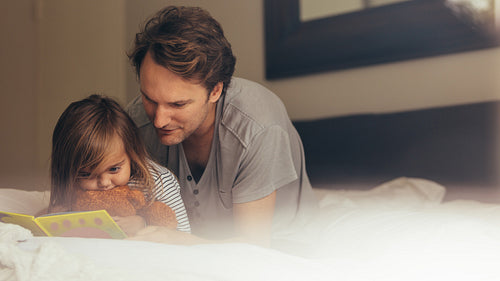 Father and daughter reading a story book