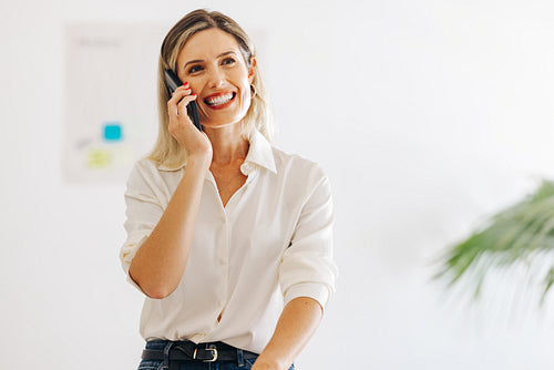 Successful businesswoman taking a phone call in a creative offic