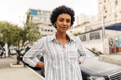 Confident young woman looking at the camera while standing outdoors