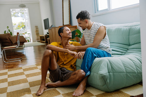 Gay couple sharing a happy moment together in a cozy home setting