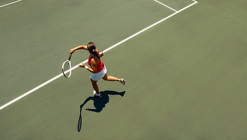 Aerial view of female tennis player executing a forehand on court