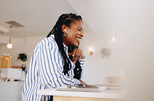 Happy young businesswoman having an online meeting with a client in a cafe