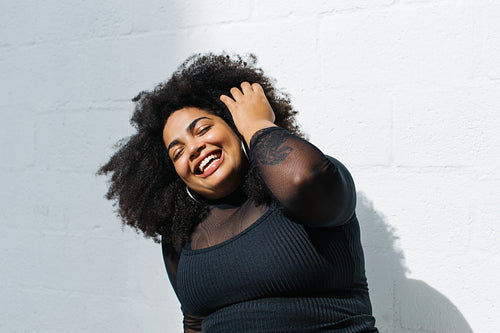 Pretty plus size woman against white wall