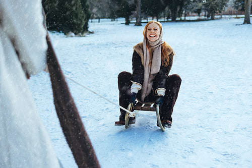 Women enjoy sledding together in a snowy park