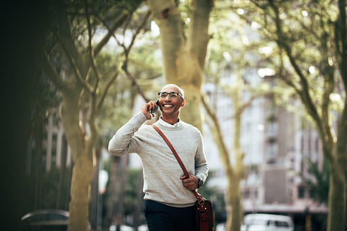 Businessman talking over mobile phone while commuting to office