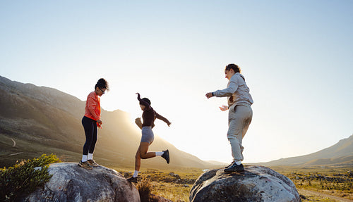Friends hiking and jumping on rocks