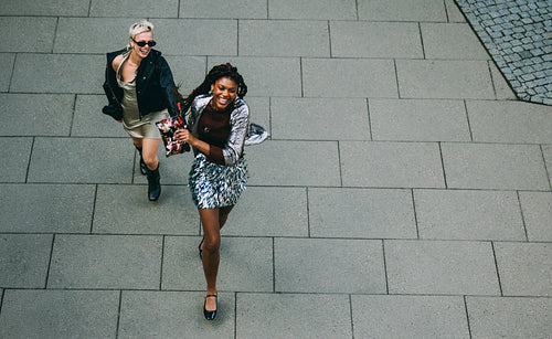 City plaza fun: friends running and laughing together