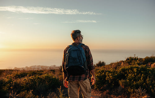 Mature backpacker looking at the view on a hilltop