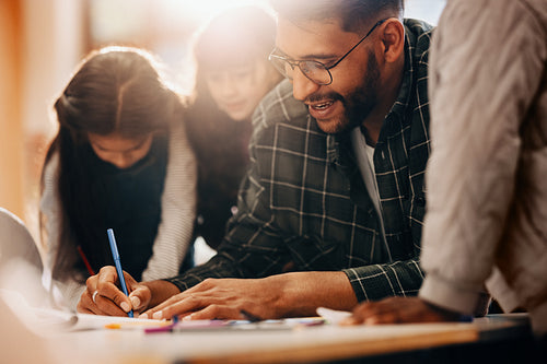 Drawing class in primary school. Teacher shows his students how to use a colouring pen