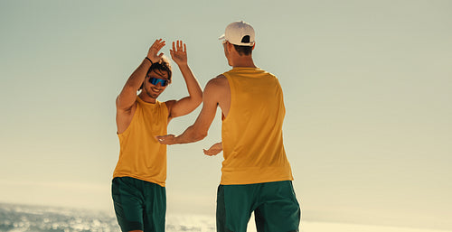 Australian volleyball champions embrace victory at coastal sunset