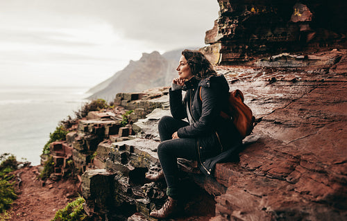 Female traveler relaxing on rocky mountain