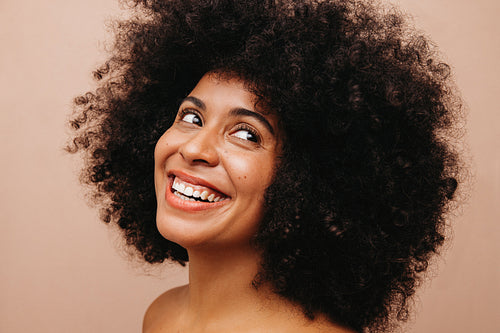 Gorgeous woman with Afro hair smiling happily in a studio