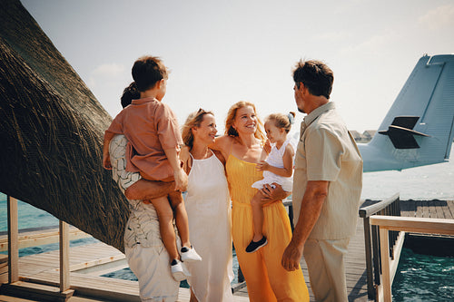 Happy family and friends arriving on holiday via airplane, smiling and excited