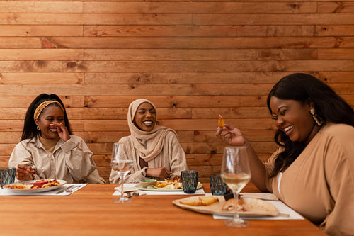 Hilarious friends laughing together in a restaurant