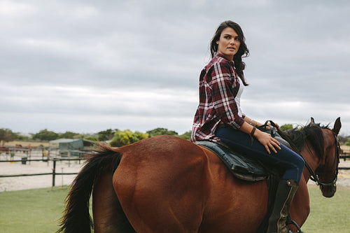Woman horse riding inside corral ranch