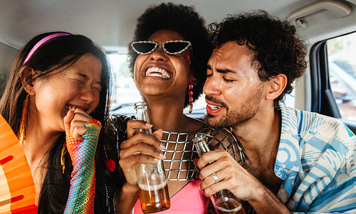 Friends celebrate carnival inside a car