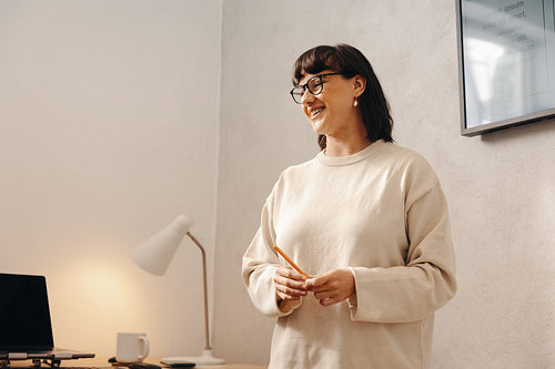 Smiling female presenting a report in a modern office setting