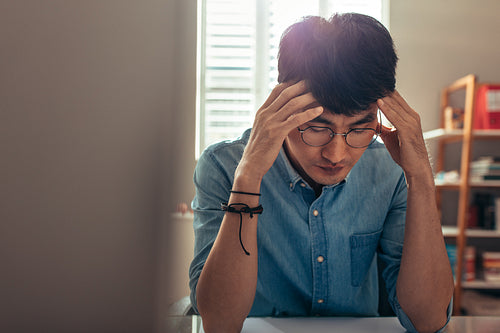 Man at his desk looking stressed and tired