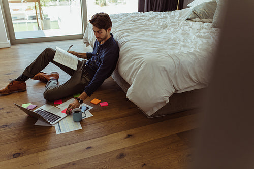Businessman working from the floor at home