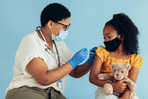 Doctor giving vaccination injection to girl