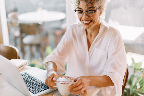 Happy businesswoman having a cup of coffee in a cafe