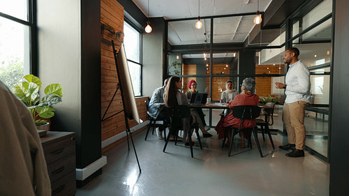 Collaborative meeting in a coworking office: Business ma having a discussion with his team in an office