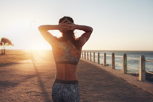  Sportswoman taking a walk by the sea at sunset