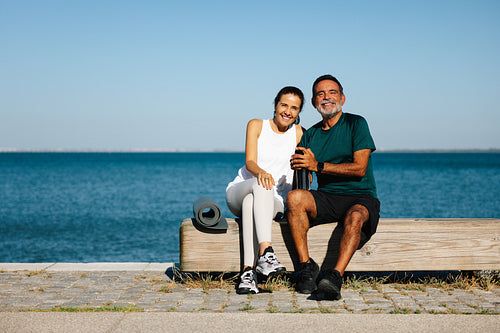 Smiling couple relaxing outdoors together near a picturesque waterfront