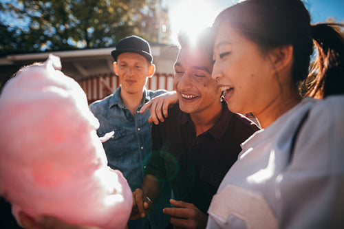 Three friends eating candy floss