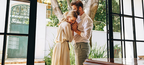 Lovely couple laughing together outside a hotel entrance