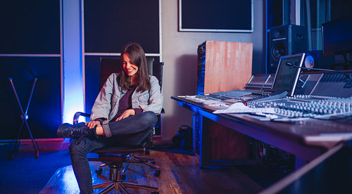 Smiling young woman music composer in recording studio