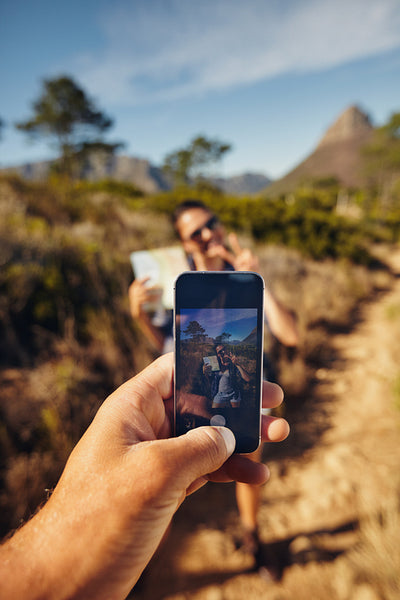 Hiker couple taking pictures with smartphone