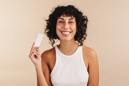 Woman holding a packet of the mini pill